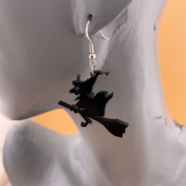 boucle d'oreille en Plexi noir opaque de 3mm avec le design d'une sorcière volant sur son blais dessin spécial halloween